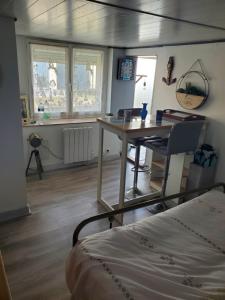 a bedroom with a desk and a bed in a room at Les flots d'Émilie et Vincent in Barneville-Carteret