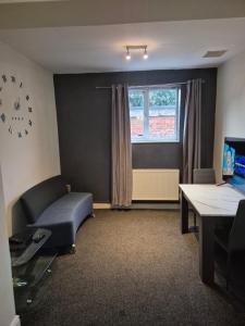 a living room with a couch and a desk and a clock at Beach Next Door Flat Retreat and Free Parking in Margate