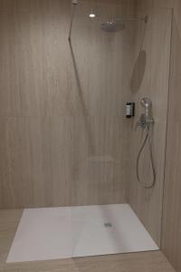 a shower with a glass door with a shower head at Superior Rooms Bohorč in Šentjur +32 photos