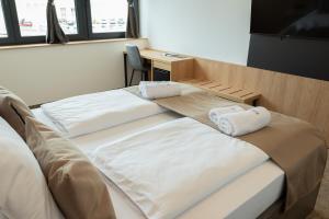 two beds in a room with towels on them at Superior Rooms Bohorč in Šentjur