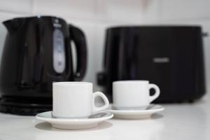 two coffee cups on a counter with a coffee maker at Hotel Asimina Laganas in Laganas