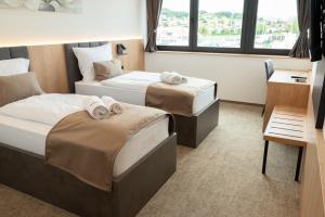 a hotel room with two beds with towels on them at Superior Rooms Bohorč in Šentjur
