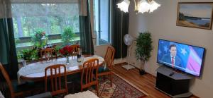 a living room with a dining table and a television at Saimaa Parkview Luxury Suite in Savonlinna