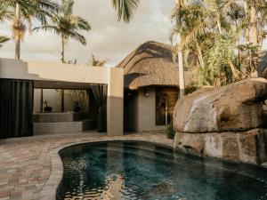 a house with a swimming pool next to a resort at Decollage Estate in Polokwane