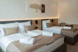 two beds in a hotel room with towels on them at Superior Rooms Bohorč in Šentjur