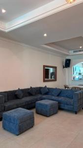 a living room with a blue couch and two blue ottools at Rose Beach 7 درة العروس in Jeddah