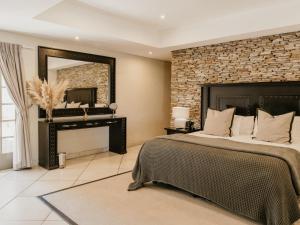 a bedroom with a large bed and a mirror at Decollage Estate in Polokwane +78 photos