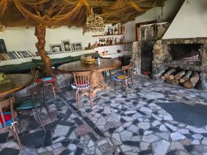 a dining room with a table and a stone fireplace at Sinemoria apartment in Sinemorets