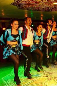 a group of people in costumes on a dance floor at BOSPHOROUS DİNNER CRUISe in Istanbul