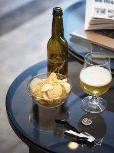 a glass of wine and a bowl of chips and a bottle at Hotel Union Geiranger Resort & Spa in Geiranger