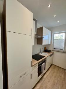 a kitchen with a white refrigerator and a sink at Bungalow Benther Berg, Contactless Check-in, Vollsaniert und Renoviert 2025 in Ronnenberg