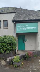 a building with a green door and some plants at Linlithgow Lodge in Linlithgow +5 photos