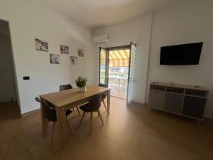 a dining room with a table and chairs and a television at B&B La Casetta in Ladispoli