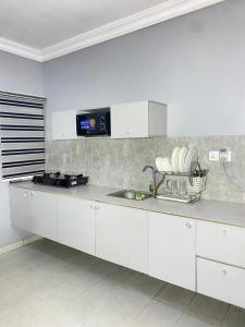 a kitchen with white cabinets and a sink at Legacy apartments in Ikeja