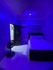 a purple bedroom with a bed and a chair at Legacy apartments in Ikeja