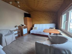 a bedroom with a bed and a table and chairs at Mewa House in Jastarnia