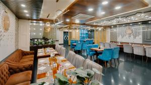 a dining room with tables and blue chairs at The Olive Hotel Srinagar in Srinagar