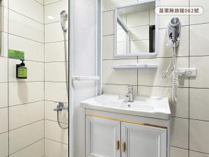 a bathroom with a sink and a shower at WE Hotel in Miaoli