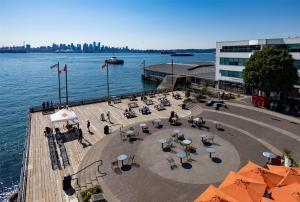 a pier with tables and umbrellas next to the water at Coast Lonsdale Quay Hotel in North Vancouver