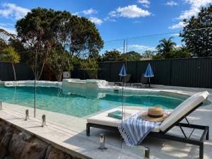 a swimming pool with a chair and a hat on it at Palacete Beach - Resort Style Stay in Culburra Beach