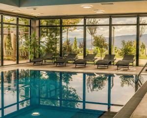 a pool in a hotel with chairs and windows at Sevsamora Resort & Spa in Saguramo