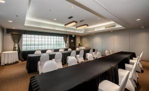a conference room with a long table and white chairs at Coast Lonsdale Quay Hotel in North Vancouver