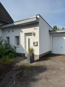 a white house with a door and a garage at Bungalow Benther Berg, Contactless Check-in, Vollsaniert und Renoviert 2025 in Ronnenberg