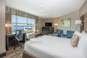 a hotel room with a bed and a desk and chair at Coast Lonsdale Quay Hotel in North Vancouver