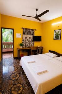 a bedroom with a large bed and a desk at selfia guest house in Majorda