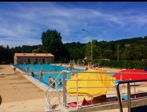 ein großes Schwimmbecken mit Menschen im Wasser in der Unterkunft La Buguoise in Le Bugue