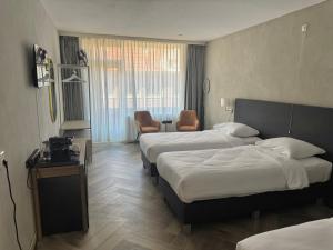 a hotel room with two beds and a room with at Hotel Mayflower in Leiden