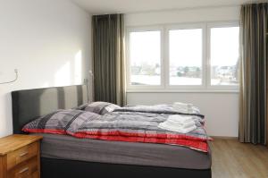 a bed in a room with two windows and a bed with towels at Apartments Blütenweg in Leichlingen