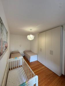 a bedroom with two beds and a crib in it at La casa di Ernesto in Carlazzo