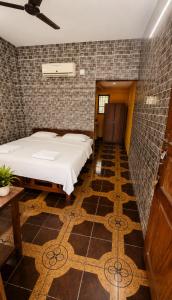 a bedroom with a bed and a tile wall at selfia guest house in Majorda