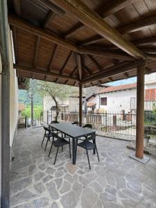 a patio with a table and chairs under a pavilion at La casa di Ernesto in Carlazzo