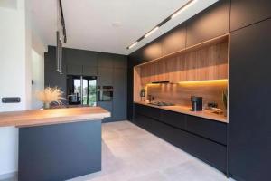 a kitchen with black and wooden cabinets and a counter at Greenery Luxury Apartment in Potamós