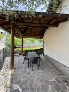 a patio with a table and chairs under a pergola at La casa di Ernesto in Carlazzo