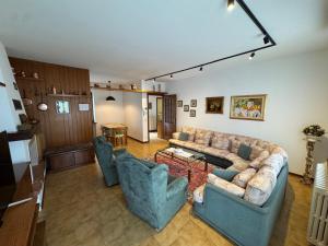 a living room with a couch and two chairs at La casa di Ernesto in Carlazzo
