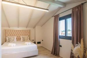 a bedroom with two beds and a large window at Greenery Luxury Apartment in Potamós