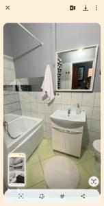 a bathroom with a tub sink and a toilet at Kawalerka in Kwidzyn
