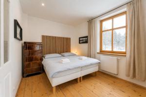 a bedroom with a bed and a window at Vila Kouty in Loučná nad Desnou