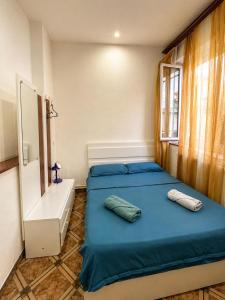 a bedroom with two blue beds and a window at Green Hostel in Yerevan