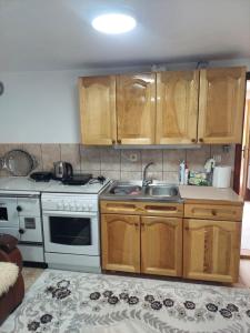 a kitchen with wooden cabinets and a stove and a sink at Downtown Apartment in Plav +5 photos