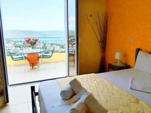 a bedroom with a bed and a view of a balcony at Villa Christine - Maisonettes with fireplace in Aliveri