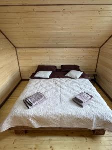 a bedroom with a bed in a wooden room at Садиба Смугар in Rostoki +39 photos