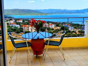 a table with a vase of flowers on a balcony at Villa Christine - Maisonettes with fireplace in Aliveri