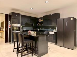 a kitchen with black cabinets and a black refrigerator at Pool Villa Ramkhamhaeng 9 in Bangkok