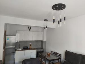 a kitchen with white cabinets and a silver refrigerator at Apartment Miki in Bar