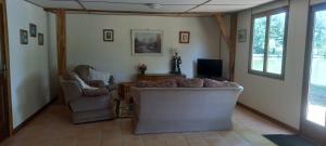 a living room with two chairs and a couch and a tv at Summers Breeze in Nantheuil