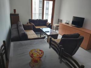 a living room with a table and couches and a television at Apartment Miki in Bar
